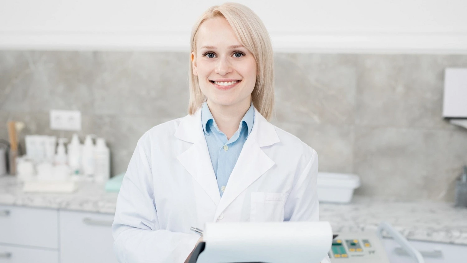 ZFA mit Klemmbrett in heller Praxis – Online-Seminar Wachstumschancen Hygienemanagement Zahnarztpraxis | Spitta Akademie