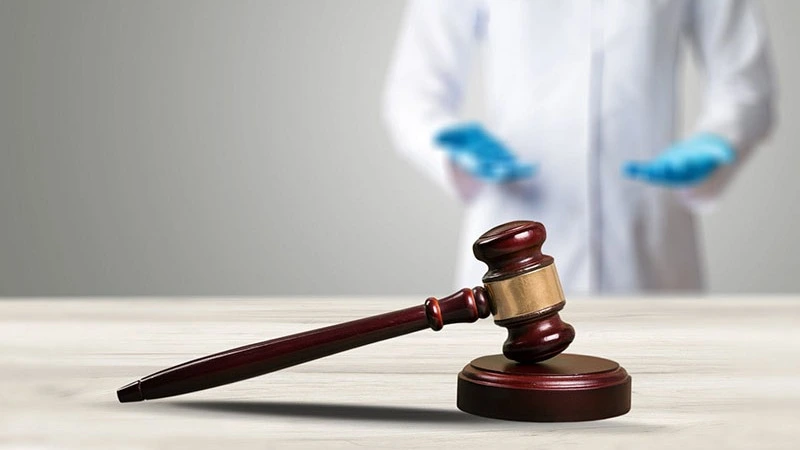 Richterhammer und Zahnarzt mit Handschuhen – Online-Seminar Patientenaufklärung in der Zahnarztpraxis | Spitta Akademie