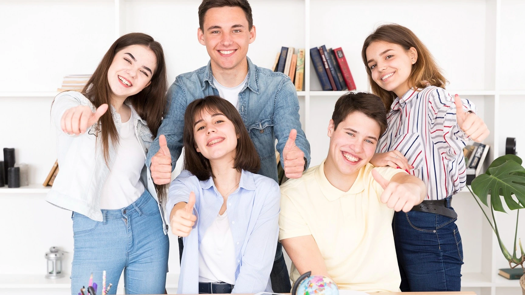 Fünf lachende Jugendliche zeigen Daumen hoch im Klassenraum – Online-Kurs Azubi-Knigge für ZFA-Auszubildende | Spitta Akademie