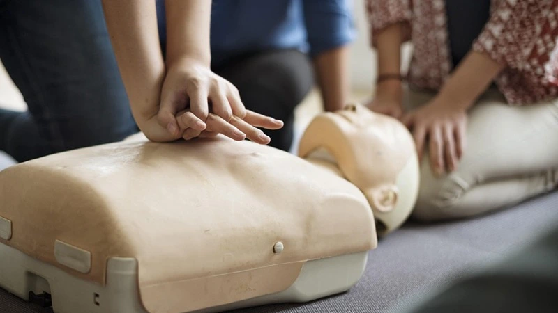 Teilnehmerin übt Herzdruckmassage an Reanimationspuppe – Online-Kurs Erste Hilfe in der Zahnarztpraxis | Spitta Akademie