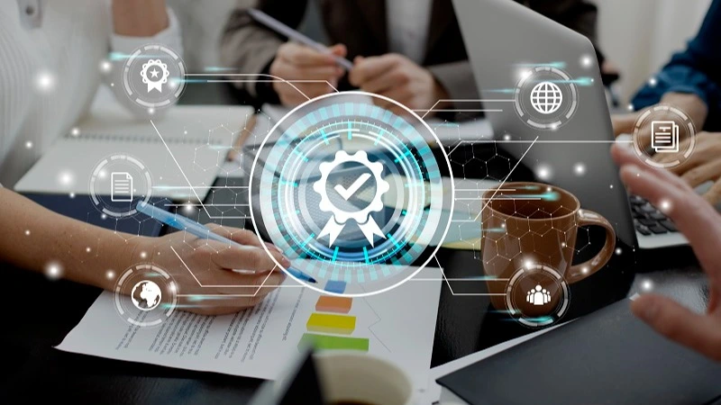 Team arbeitet an Laptop mit digitalen Qualitätsmanagement-Icons – Online-Kurs Qualitätssicherung in der Zahnarztpraxis | Spitta Akademie