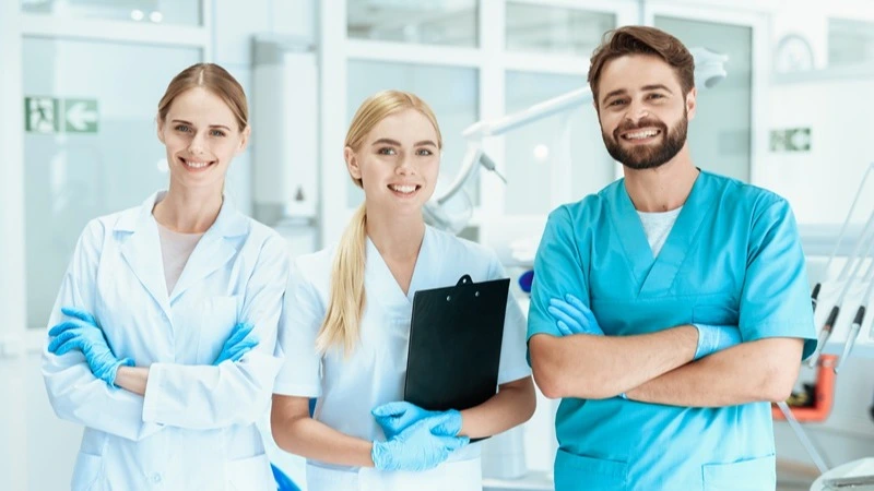 Praxisteam lächelt im Behandlungszimmer – Infoveranstaltung Personalmanager Gesundheitswesen IHK | Spitta Akademie
